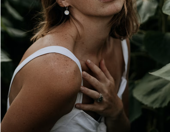 Femme avec main placée sur la poitrine évoquant l'auto-contact comme ressource dans la surcharge émotionnelle