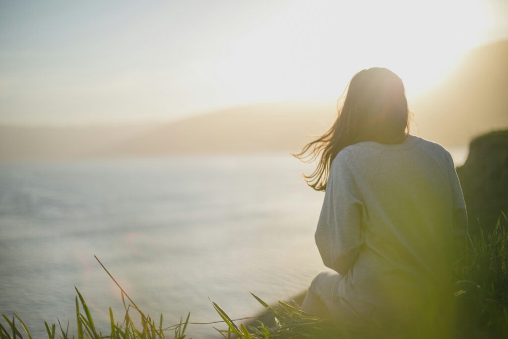 Femme observant l'horizon, épaules courbées