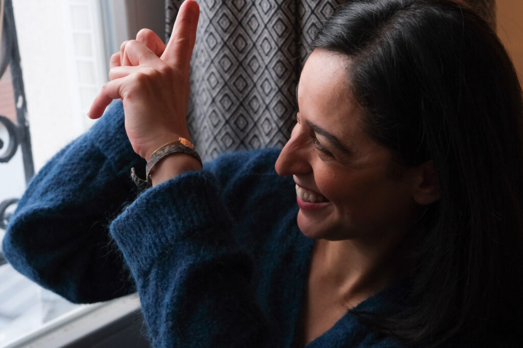 Femme observant par la fenêtre et souriant, évoquant un glisser