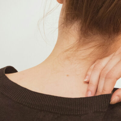 Femme massant sa nuque tendue, un signe de stress possible