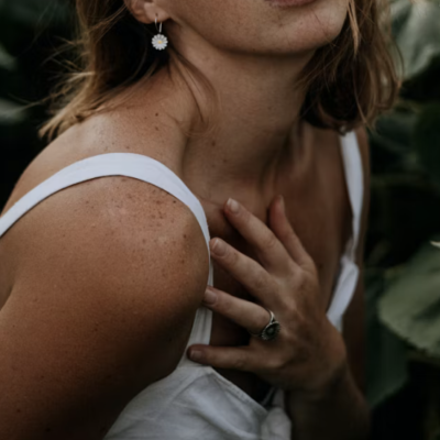 Femme avec main placée sur la poitrine évoquant l'auto-contact comme ressource dans la surcharge émotionnelle