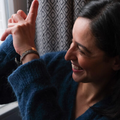 Femme observant par la fenêtre et souriant, évoquant un glisser